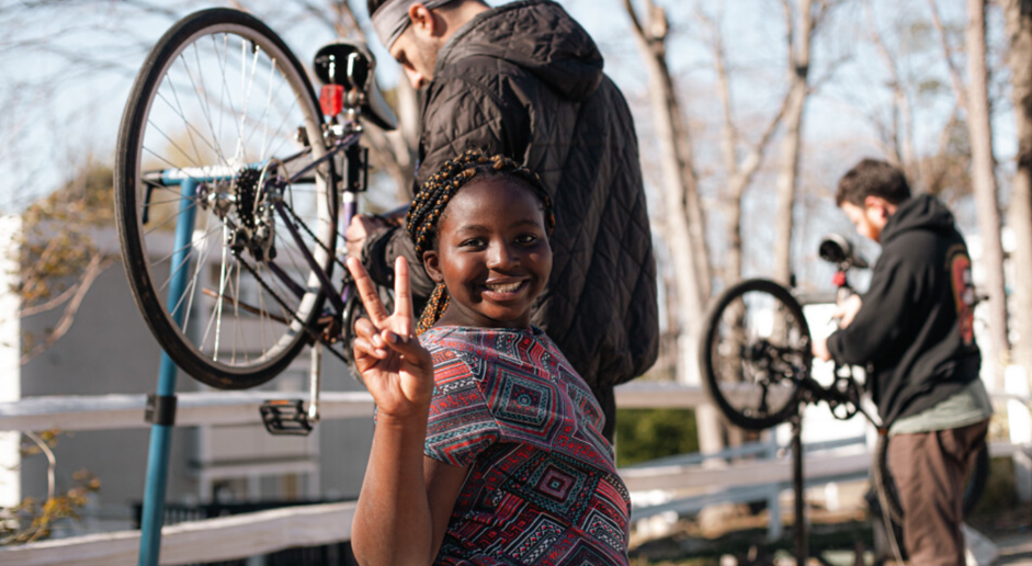 little girl with bicycles in the background