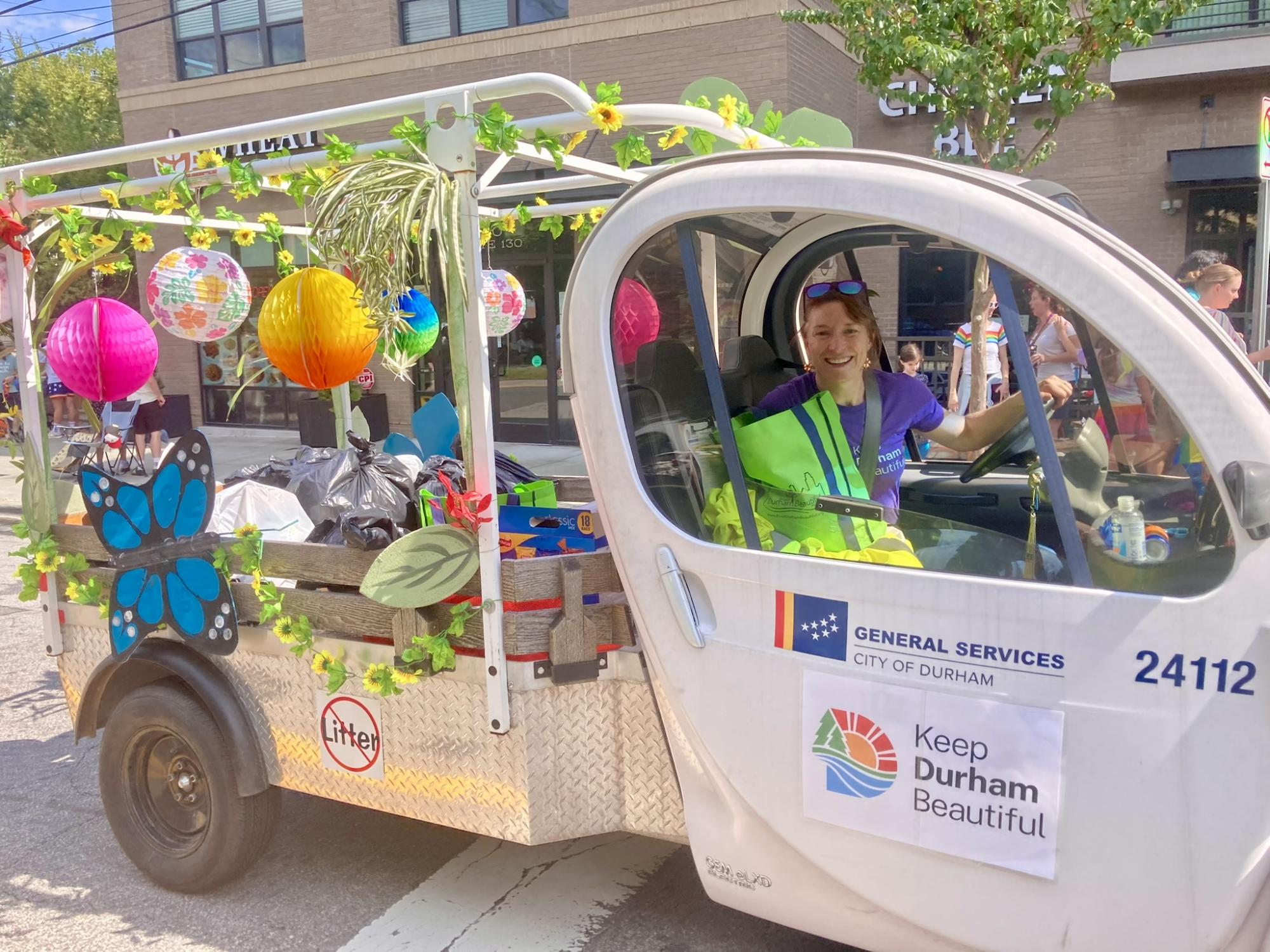 woman in small truck that says General Services, City of Durham with spring decorations