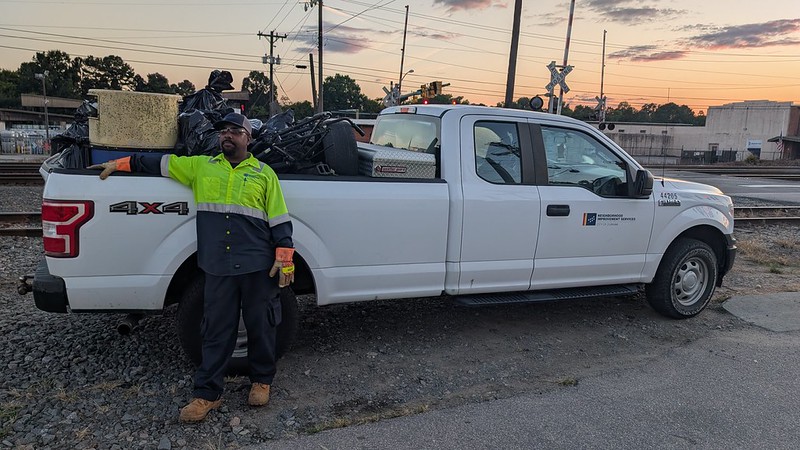 Man in maintenance uniform next to a white truck